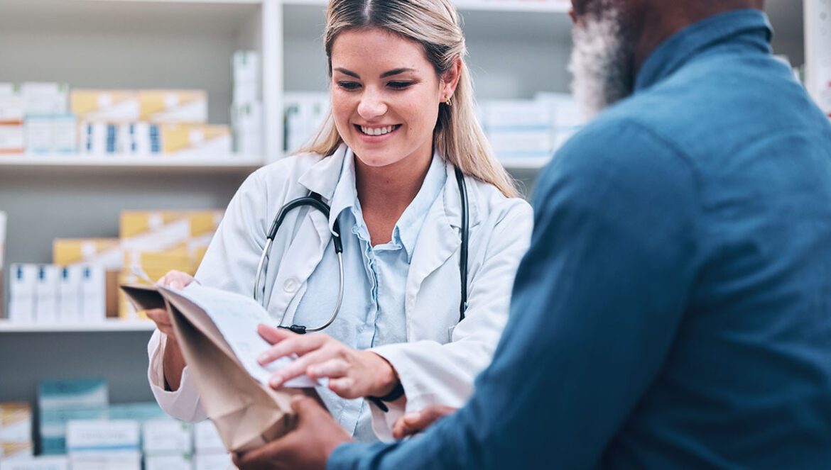 Healthcare, pharmacist and man at counter, medicine, prescription drugs and happy service at drug store. Health, wellness and medical insurance, black man and woman at pharmacy for advice and pills.