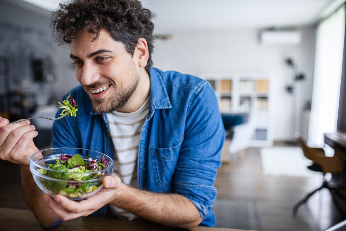 Smiling Man Enjoying Healthy Salad at Home