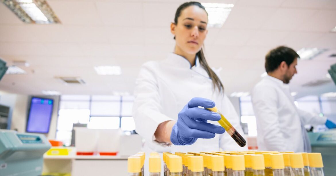 Lab technician holding blood vial 1200 628 facebook